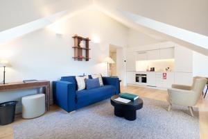 a living room with a blue couch and a table at Ando Living - Santa Justa 79 House in Lisbon