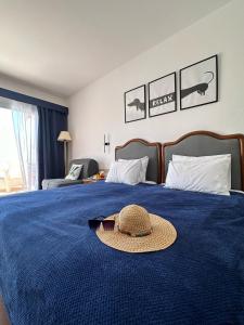 a hat on a bed with a blue blanket at Domina Coral Bay Sultan Vista Mare Uno in Banī Ghālib