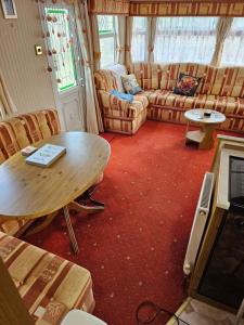a living room with a table and a couch at Sunrise Cottage central heated Southview Parkdean SKEGNESS Lincolnshire in Winthorpe