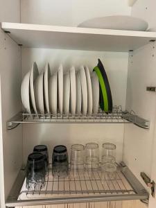 a shelf with plates and glasses in a refrigerator at Appartamento immerso nella tranquillità in Bobbio