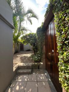 a hallway of a house with a gate and a palm tree at Dolphin Circle Bed and Breakfast in Plettenberg Bay