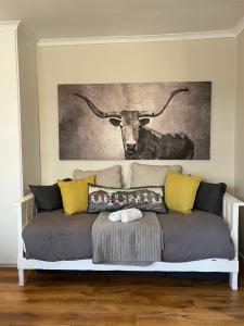 a couch with a picture of a bull on the wall at Dolphin Circle Bed and Breakfast in Plettenberg Bay