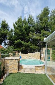 a swimming pool in a yard with a stone wall at Apartment Carpe Diem Ivan Dolac in Ivan Dolac +33 photos