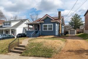 a blue house on a street with a driveway at Luxury Short and Midterm Hyde Park Getaway in Cincinnati