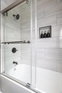 a bathroom with a shower with a bath tub at Luxury Short and Midterm Hyde Park Getaway in Cincinnati