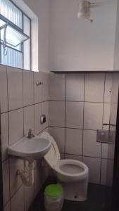 ein Badezimmer mit Toilette und Waschbecken in der Unterkunft Seu lar na Praia, Condomínio Vila Gustavo-excelente localização in Caraguatatuba