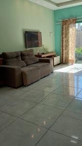 a living room with a brown couch in a room with a window at COP30 Casa Completa in Barcarena