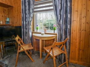 a room with a table and two chairs and a window at Rose Cottage in Stranraer
