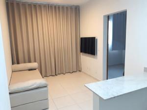 a living room with a chair and a television at Samambaia East Side · Comfort in Samambaia in Brasilia