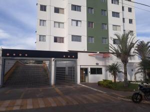 a large white building with a garage in front of it at Samambaia East Side · Comfort in Samambaia in Brasilia