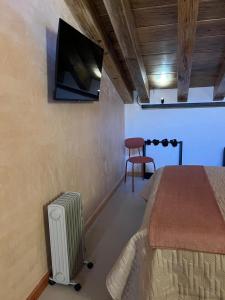 ein Schlafzimmer mit einem Bett, einem Fernseher und einem Stuhl in der Unterkunft Casa Coco H3 Luna in San Cristóbal de las Casas