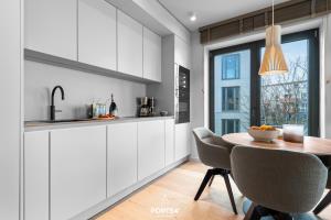 a kitchen with a table and chairs and a window at Nordic Suite List auf Sylt in List