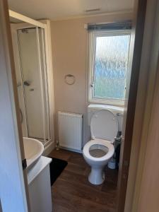 a bathroom with a toilet and a sink and a window at The Springs 22-Sara in Winthorpe +21 photos