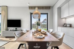 a kitchen and dining room with a wooden table and chairs at Anchorage Suite List auf Sylt in List