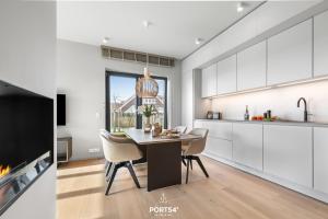 a kitchen with a table and chairs and a fireplace at Anchorage Suite List auf Sylt in List