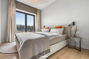 a bedroom with a large bed and a window at Anchorage Suite List auf Sylt in List