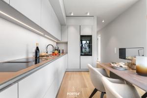 a kitchen with white walls and a counter and chairs at Anchorage Suite List auf Sylt in List