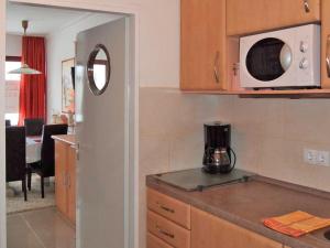 a kitchen with a microwave on top of a counter at Ferienwohnung Thordsen 2 in Burgtiefe auf Fehmarn 