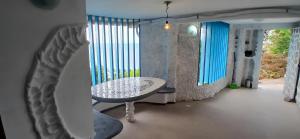 a table and a chair in a room with windows at Flor de Lótus Privilege in Japaratinga