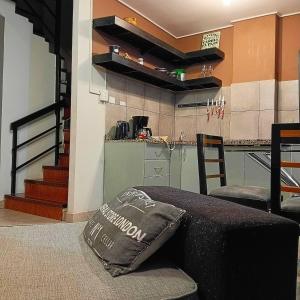 圣萨尔瓦多德朱APARTOTEL oFFice CENTRAL的客厅里有一张沙发和一个厨房