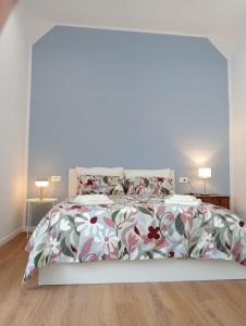 una camera da letto con un grande letto con un copriletto floreale di Il Gatto e Pirouette a Napoli