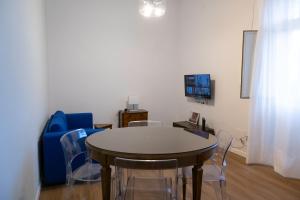 una sala da pranzo con un tavolo e un divano blu di Il Gatto e Pirouette a Napoli