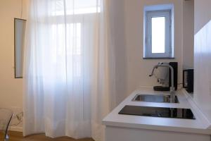 una cucina con un lavandino e una finestra di Il Gatto e Pirouette a Napoli Altre 42 foto