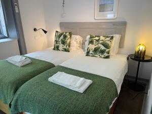 two beds with green and white towels on them at Historical Lisbon Apartments in Lisbon
