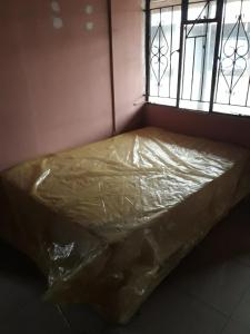 een bed bedekt met plastic voor een raam bij Ekuhlaleni in Randfontein