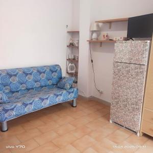 a living room with a blue couch in a room at Casa Vacanza Il Pontile Mini Appartamento in Cipollina