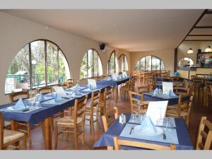 un ristorante con tavoli e sedie blu e finestre di Camping Village Panoramico Fiesole a Fiesole