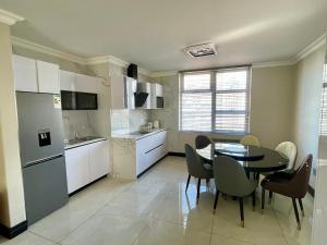 a kitchen and dining room with a table and chairs at Durban Suites at Oceanic in Durban