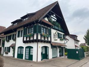 a white house with green shutters at Exclusive FWO mit kleinem beheizbarem Pool zum Schwimmen und Massieren in Hausen