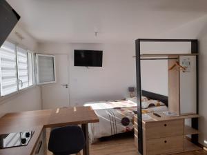 a small bedroom with a bed and a desk and a desk at CHARMANT STUDIO DANS UNE MAISON NEUVE in La Roche-sur-Yon