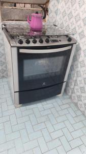 コルンバにあるCasa de 90m2 toda sua aconchegante e centralのピンクの鍋が付いたキッチンコンロ