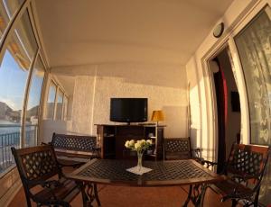 a dining room with a table and a tv on a balcony at Olga Bashinskaya in Sutomore