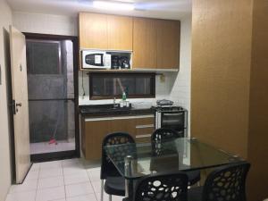 a kitchen with a table and chairs and a microwave at FLAT MONTE CASTELO - Flat10 Mod04 in Sairé