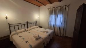 a bedroom with two beds and a large window at VENTA DE LA SISA in Sisante +14 photos