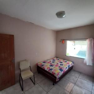 a bedroom with a bed and a chair and a window at COP30 Casa Completa in Barcarena +12 photos