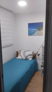 a bedroom with a bed with a blue comforter at departameto 3 dormitorios in Coquimbo
