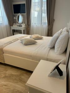 a bedroom with two beds and a table with a mirror at Pensiunea Carpe Diem Spa in Dumbrăviţa