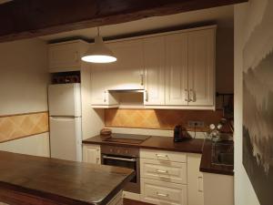 a kitchen with white cabinets and a white refrigerator at Casa rural Palotes in Nerpio