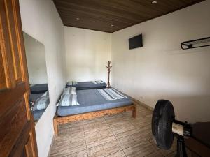 QUARTOS Praia do Tombo Guarujá في غوارويا: غرفة نوم بسرير في زاوية الغرفة