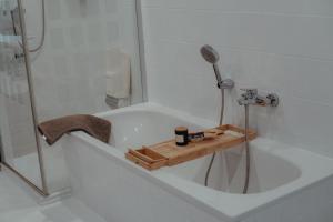 a bath tub with a shower and a wooden tray in it at EifelNest Blankenheim 2 in Blankenheim