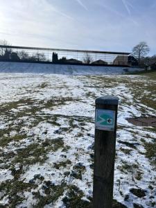 a sign on a pole in a field with snow at EifelNest Blankenheim 2 in Blankenheim +10 photos