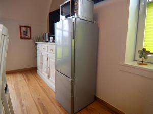 a kitchen with a stainless steel refrigerator in a room at Charmante Ferienwohnung in Kirchdorf Insel Poel in Oertzenhof