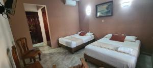 Un pat sau paturi într-o cameră la Hotel Rosa de los vientos