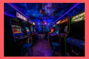 加登格罗夫Galaxy Quest: Playground, Arcade, and Endless Fun的一间设有街机游戏和 ⁇ 虹灯的房间