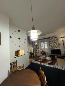 comedor con mesa y reloj en la pared en Little bay apart 2, en Kotor