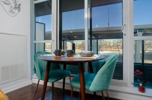 a table and chairs in a room with windows at Downtown Cozy 1BR Condo- Steps from Lake & King street in Toronto +17 photos